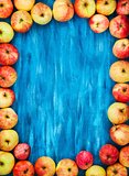 Frame of fresh red apples on  painted blue wooden background