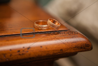 Wedding rings on the edge of a wooden table