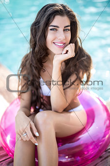 Girl in swimsuit sits on rubber ring