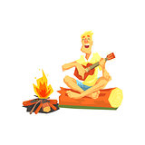 Guy Playing Guitar Sitting On A Log Next To Bonfire
