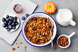 Healthy breakfast. Fresh granola, muesli with pumpkin seeds,pecan nuts in white bowl. Top view