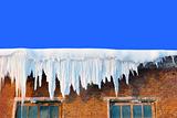 Snow cover on roof of old textile fabric with icicles