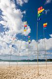 Flagpoles with colorful flags on the beach