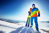 Happy skier in colorful clothes with ski
