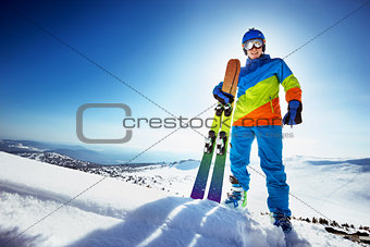 Happy skier in colorful clothes with ski