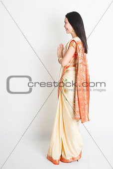 Side view woman in Indian sari dress greeting