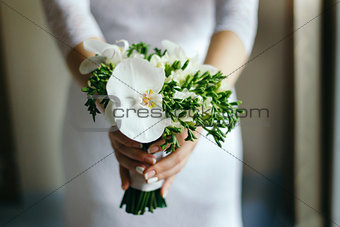 Bride with a bouquet of white Orchid in the hands