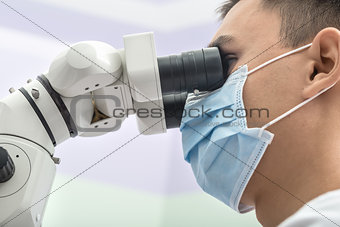 Dentist using a dental microscope