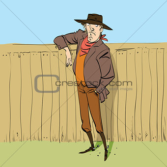 Cowboy in full figure standing near a fence