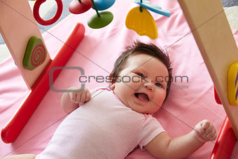 Cute Baby Girl Laying On Pink Blanket Playing With Mobile