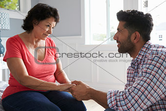 Adult Son Comforting Mother Suffering With Dementia