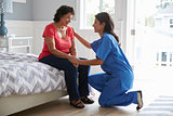 Nurse Making Home Visit To Senior Hispanic Woman