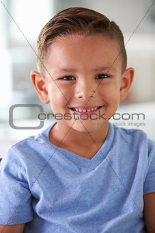 Head And Shoulders Portrait Of Smiling Hispanic Boy At Home
