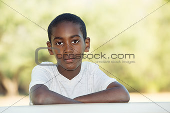 Serious boy with folded arms at table