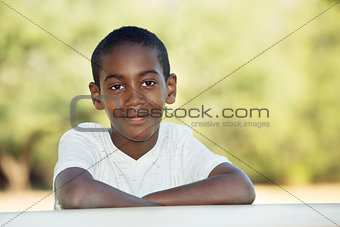 Cute child with folded arms at table