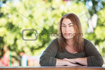 Pretty woman seated at table outside