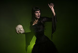 Sensual witch holding a skull in her hand 