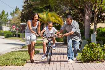 African American Family WIth Boy Riding Bike & Happy Parents 