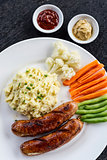 german sausage with mashed potato and vegetables meal