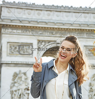 fashion-monger near Arc de Triomphe showing victory gesture
