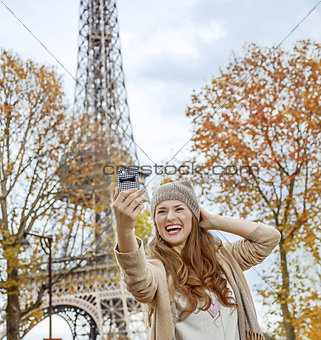 elegant woman in Paris, France taking selfie with phone