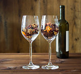 Autumn leaves in a wine glass and wine bottle on wooden table background