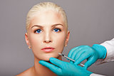 Cosmetic plastic surgeon injecting aesthetics face
