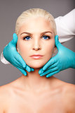 Cosmetic plastic surgeon touching aesthetics face