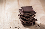 Chocolate Bars Stack on Wooden Table.