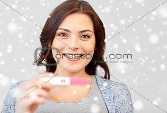 happy smiling woman holding home pregnancy test