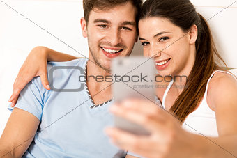 Couple on bed making selfies