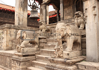 Ancient stone statue of elephants and dogs on steps in Bhaktapur