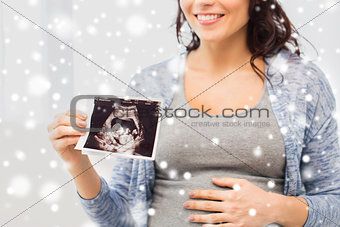 close up of pregnant woman with ultrasound image