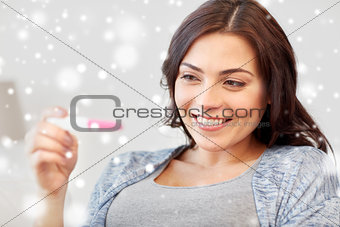 happy woman looking at home pregnancy test