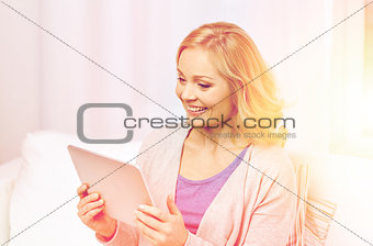 happy middle aged woman with tablet pc at home