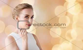 woman in white with jewelry over holidays lights