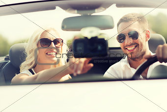 happy couple usin gps navigation system in car