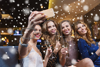 women with champagne taking selfie at night club