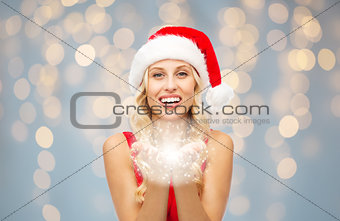 happy woman in santa hat holding fairy dust