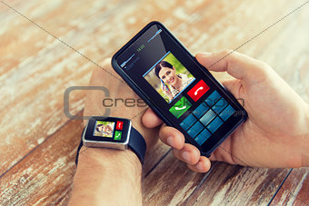 close up of hands with smart phone and watch