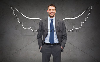 happy businessman with angel wings over gray