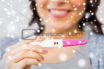close up of happy woman with home pregnancy test
