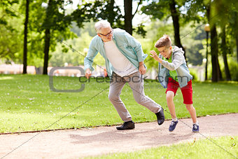 grandfather and grandson racing at summer park