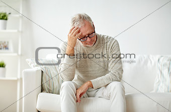 senior man suffering from headache at home