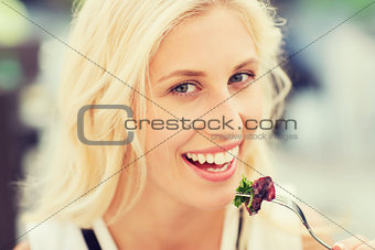 happy woman eating dinner at restaurant terrace