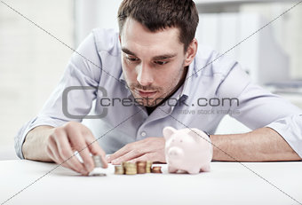 businessman with piggy bank and coins at office