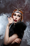 Beautiful girl with smoky eyes and red lips holding cigarette