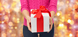 close up of woman in pink sweater holding gift box