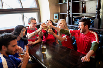 football fans clinking beer glasses at sport bar