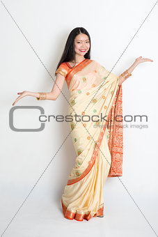 Young girl in Indian sari dress welcoming